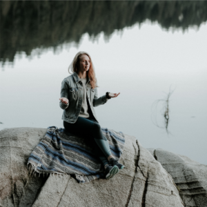 Femme méditant au bord d'un lac