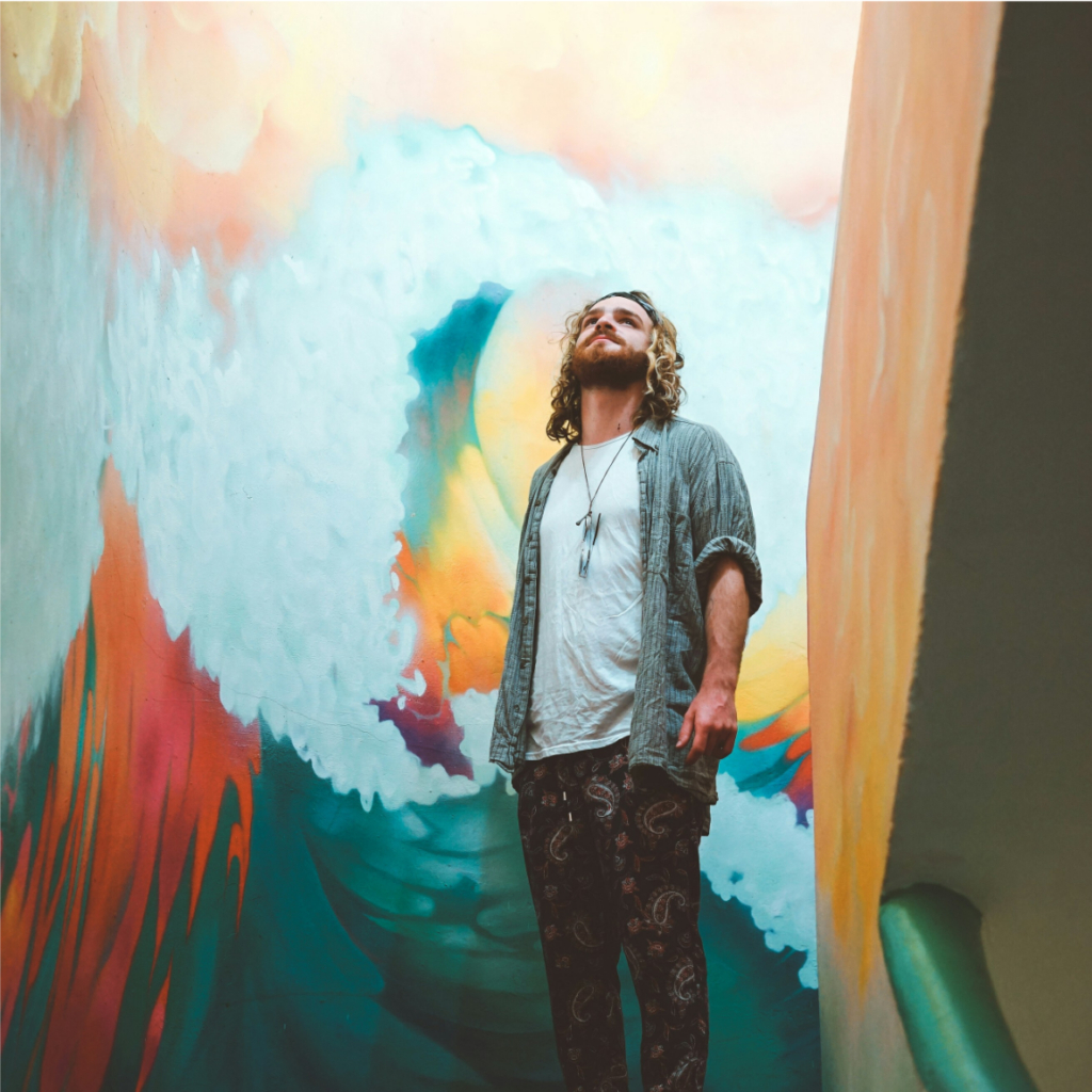 Un homme en préparation mentale devant une fresque murale colorée grâce à l'hypnose.