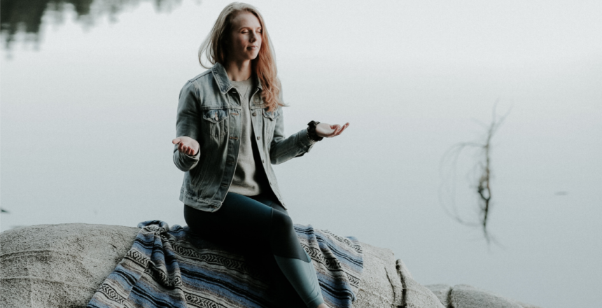 Femme méditant au bord d'un lac